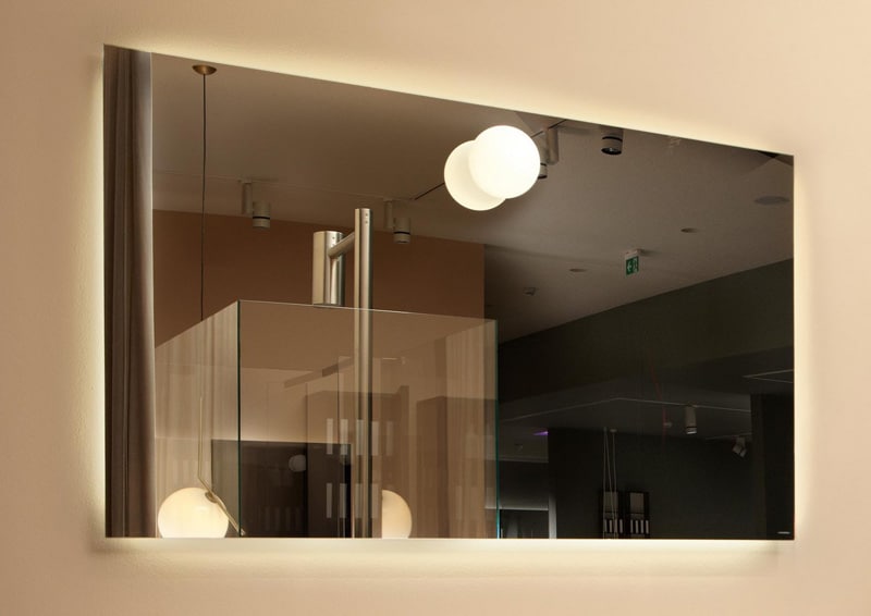 luce in bagno: non solo lampade, ma giochi di riflessi, trasparenze e rimandi